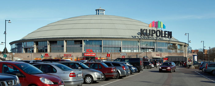 Bild på Handelscentrat Kupolen i Borlänge med bilar parkerade framför