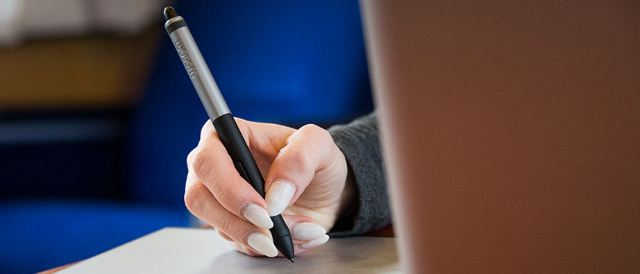 En hand med en penna på en ritplatta.