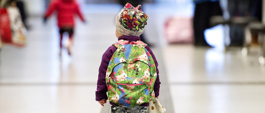 Baksidan på ett barn med en ryggsäck på ryggen