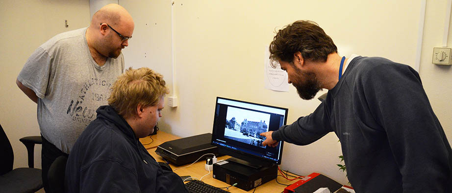 Tre personer tittar på en bild på datorn