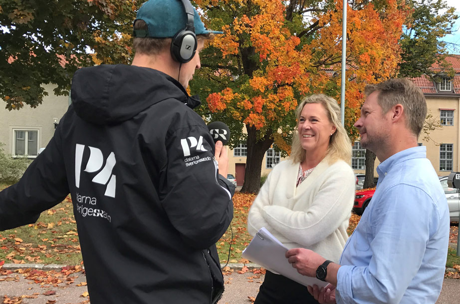 En reporter från P4 Dalarna står med ryggen mot kameran och intervjuar Maria Brodén och Johan Björklund.