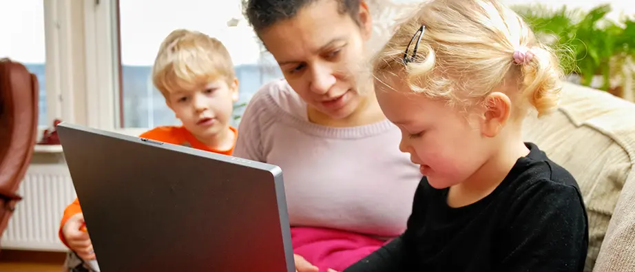 En mamma och två barn sos tittar på en dataskärm