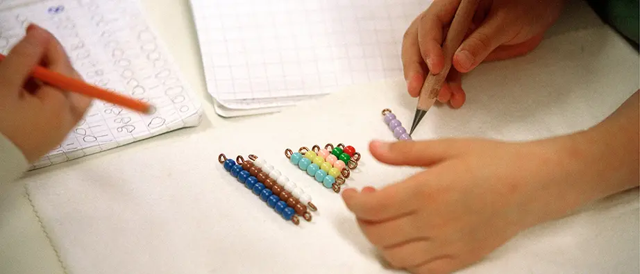 Barnhänder som räknar matematik med hjälp av pärlor