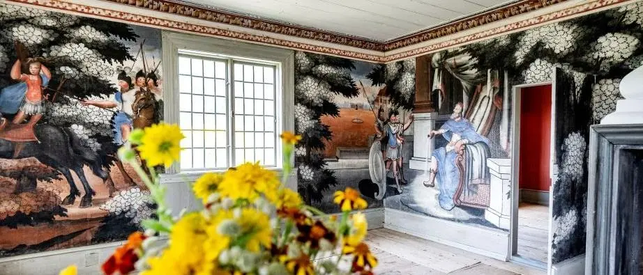Dekorerade väggar inne i Linnés bröllopsstuga