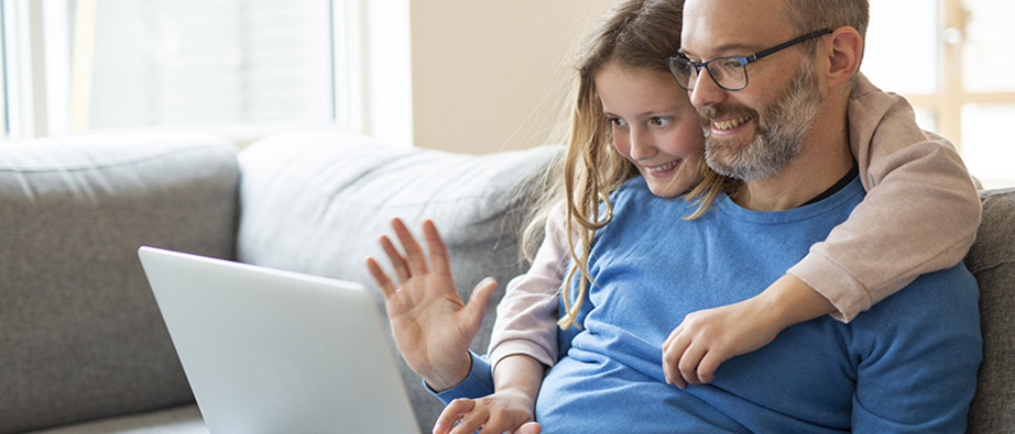 Dotter kramar om pappa samtidigt som de tittar på en datorskärm