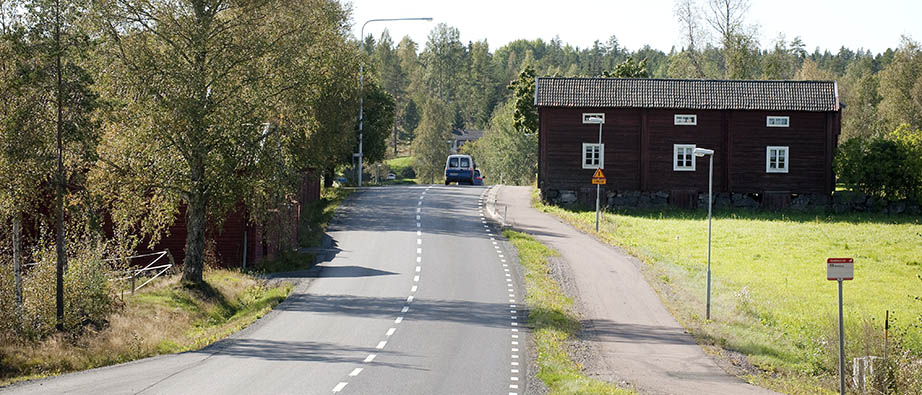 Ett rött hus och vägen genom byn Stråtenbo